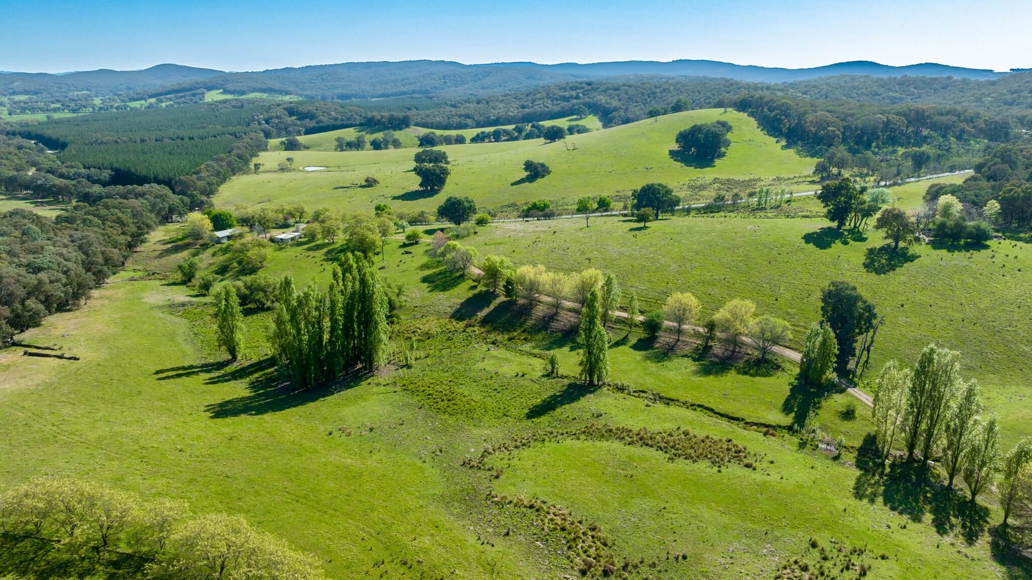 An aerial view of a dirt road and paved road on the property