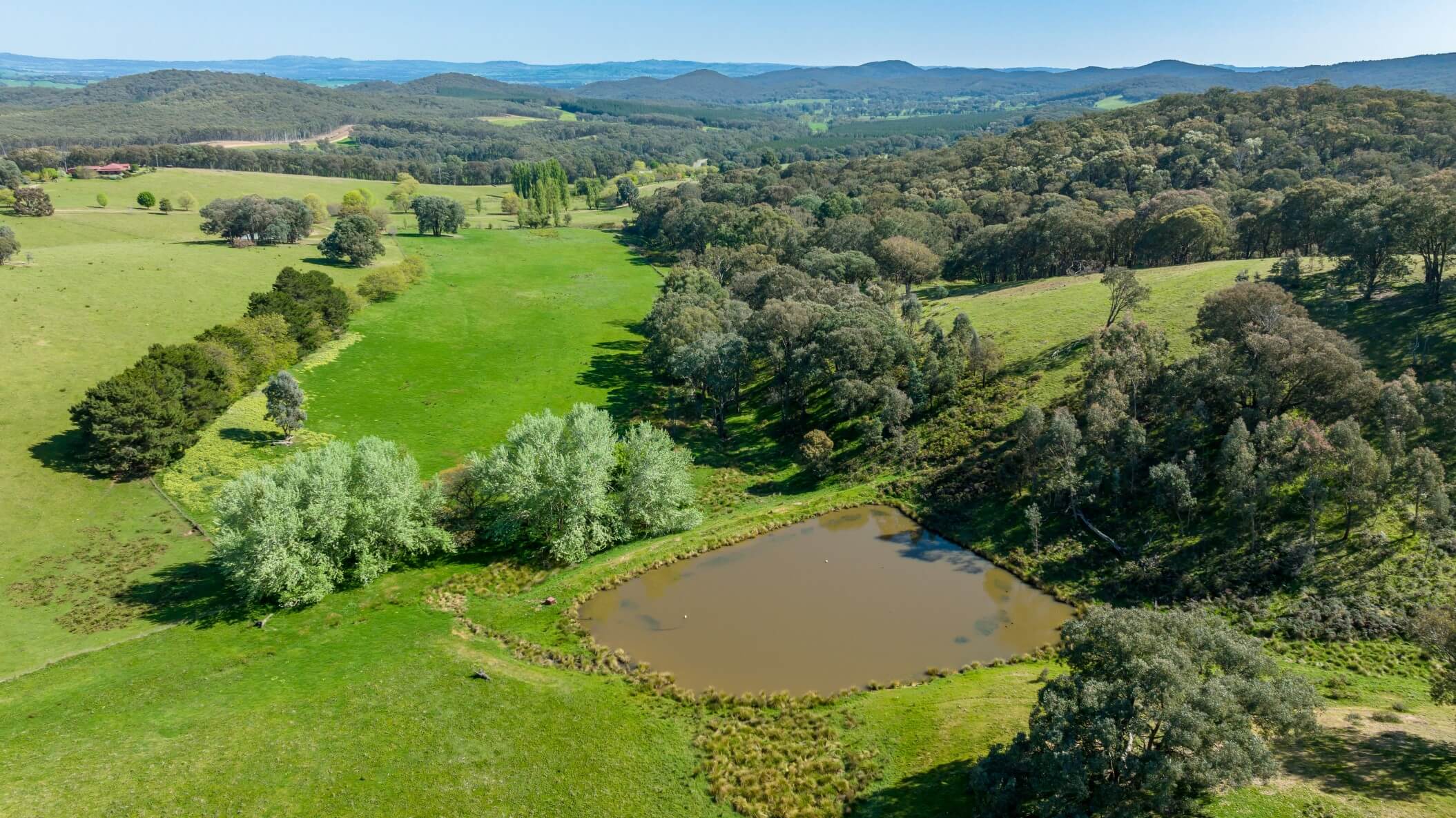 An aerial view of the surrounding fields, forests and dam