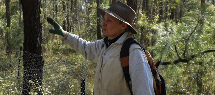 Photo of a woman pointing to a tree.