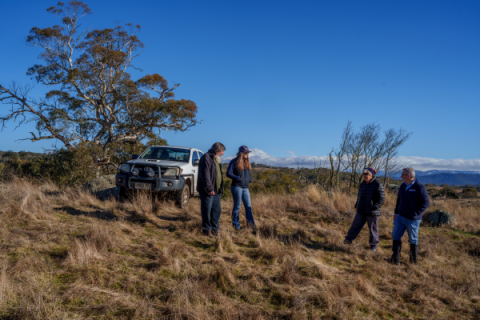 Four people stand talking on the Beauredden property