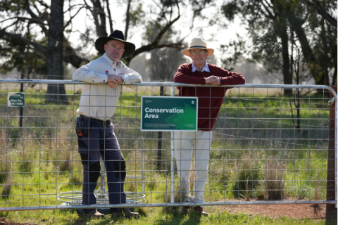 David Sloane and BCT worker stand behind a gate with a conservation sign attached