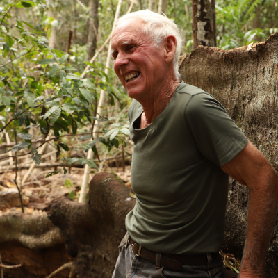 Don Durant leans against a large tree smiling